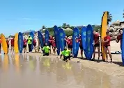 Alumnos de Ohana Surf Tres Piedras con sus tablas en la orilla